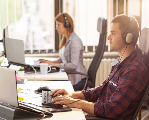 two workers sitting at desk working