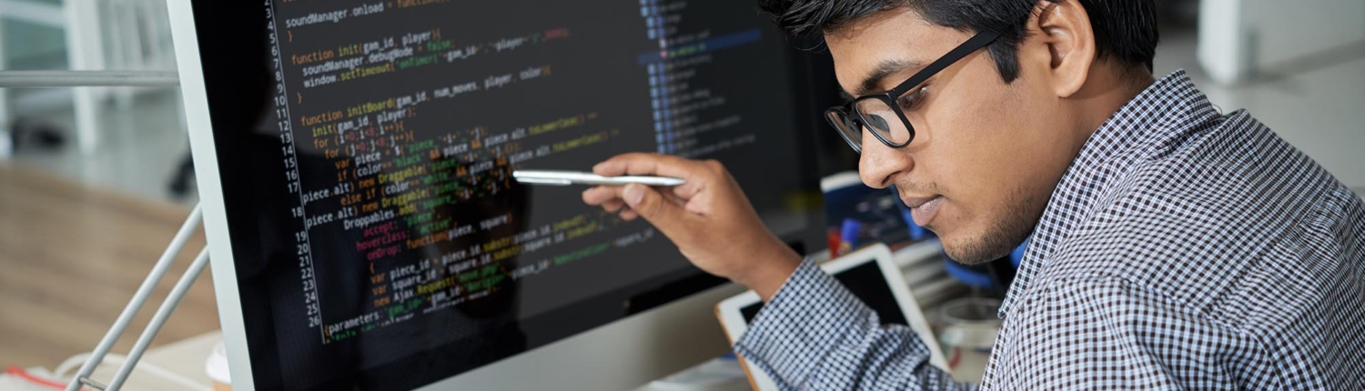 Image of a person reviewing code on a computer screen.